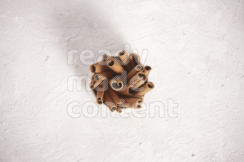 أعواد القرفة في وعاء بيج علي خلفية بيضاء