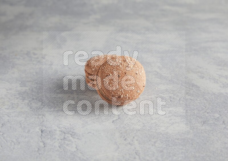 45º Shot of two Brown Hazelnuts macarons  on white  marble background