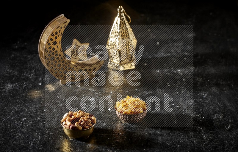 Nuts in a metal bowl with raisins beside golden lanterns in a dark setup