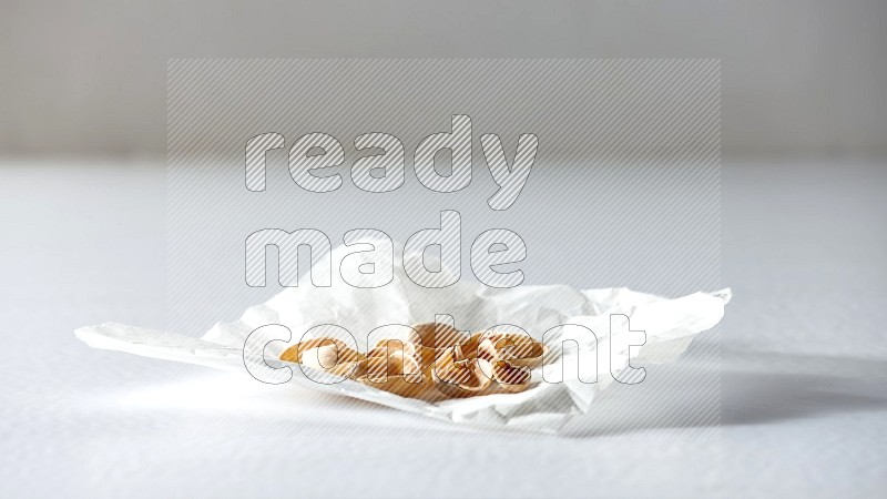 Pistachio peels on a crumpled piece of paper on a white background in different angles