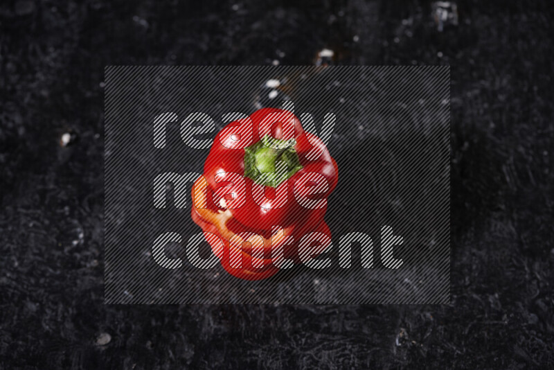 Red bell pepper slices on black background