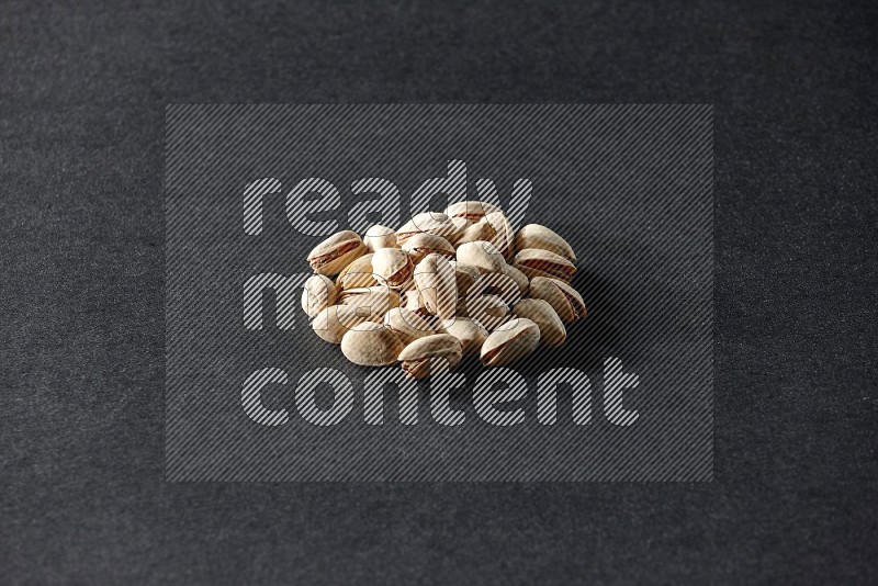 A bunch of pistachios on a black background in different angles