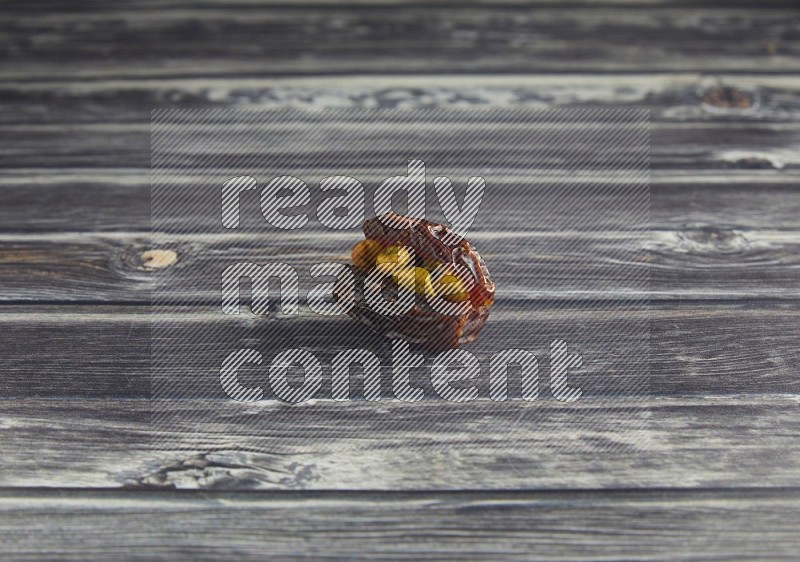 pistachio stuffed madjoul date on a wooden grey background