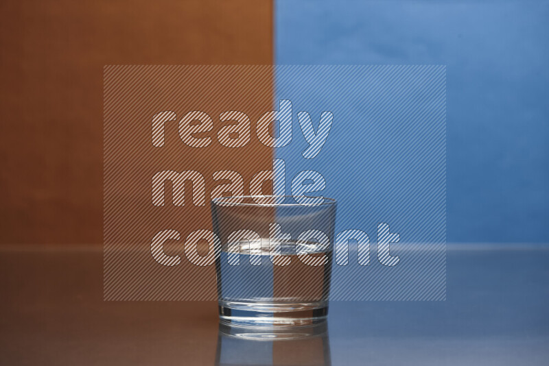 The image features a clear glassware filled with water, set against brown and blue background