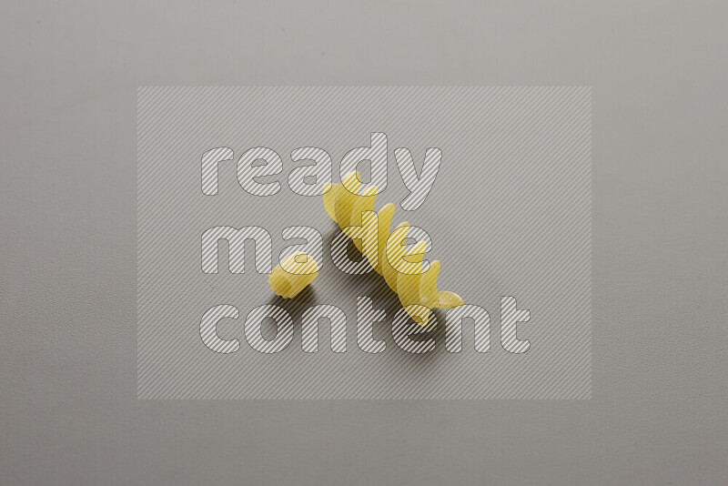 Small rings pasta with other types of pasta on grey background