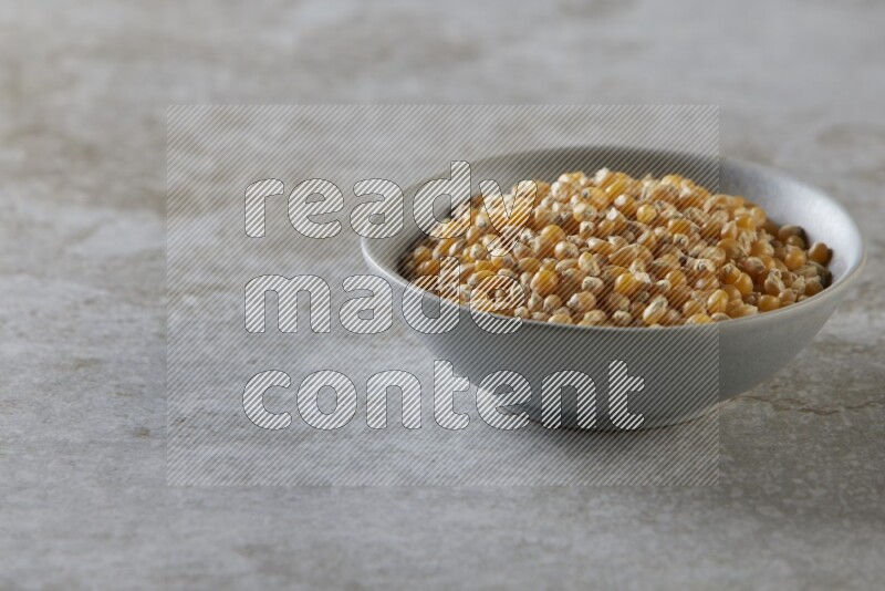 corn kernel in a gray ceramic bowl on a grey textured countertop