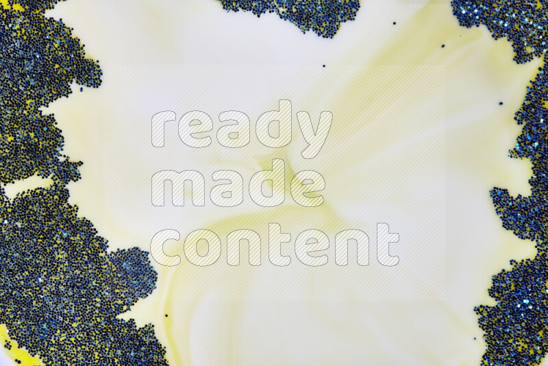 A close-up of sparkling blue glitter scattered on swirling yellow background