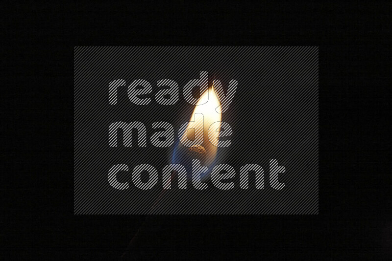 A burning matchstick isolated on dark backdrop