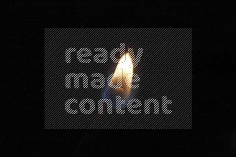 A burning matchstick isolated on dark backdrop