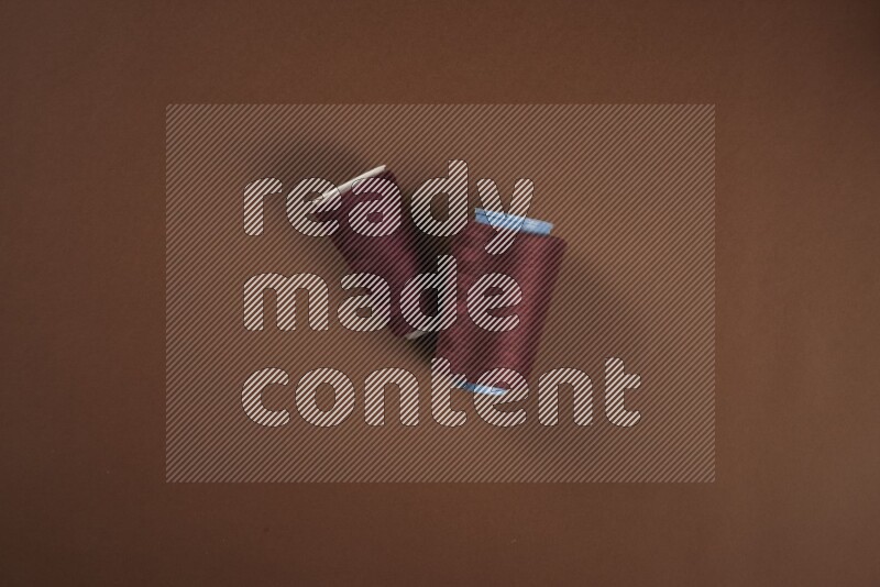 مجموعة من أدوات الخياطة والتفصيل حمراء اللون على خلفية بنية