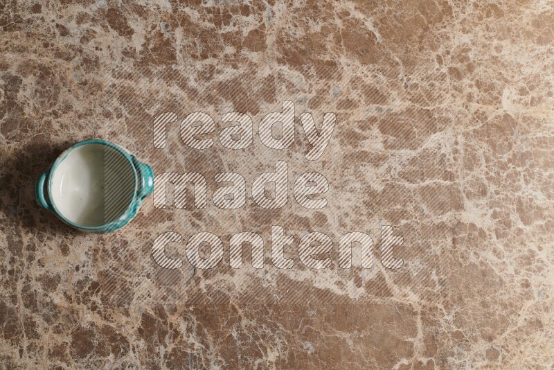 A multicolored pottery bowl on beige marble background