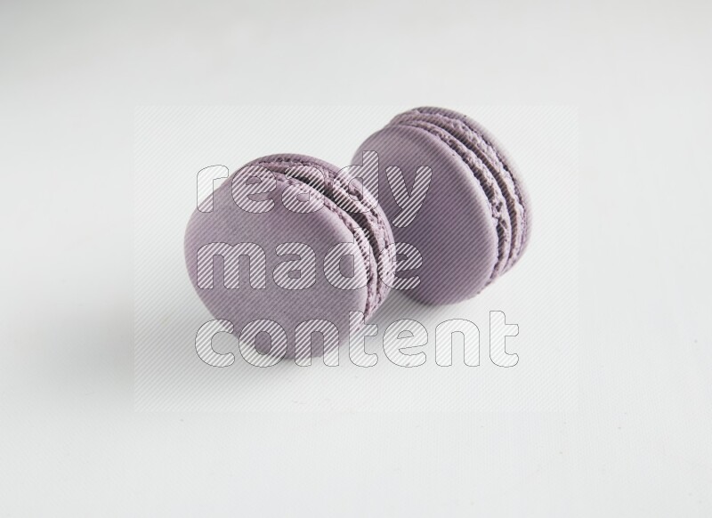 45º Shot of two Purple Blueberry macarons on white background