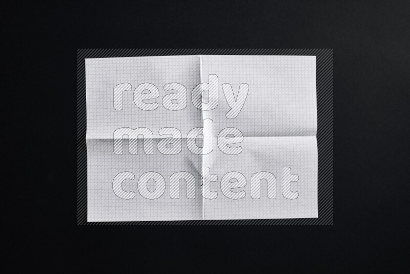 Folded notebook sheet on black background