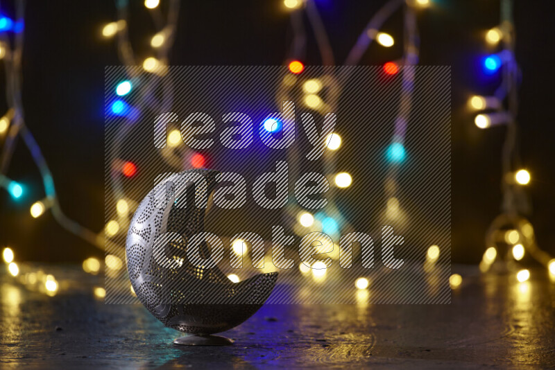 A traditional ramadan lantern surrounded by glowing fairy lights in a dark setup