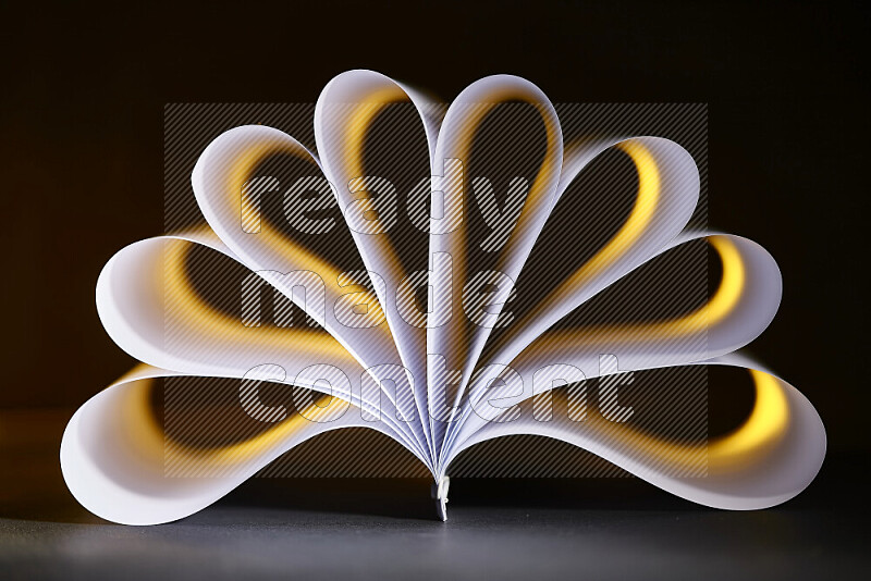 An abstract art piece displaying smooth curves in yellow and white gradients created by colored light