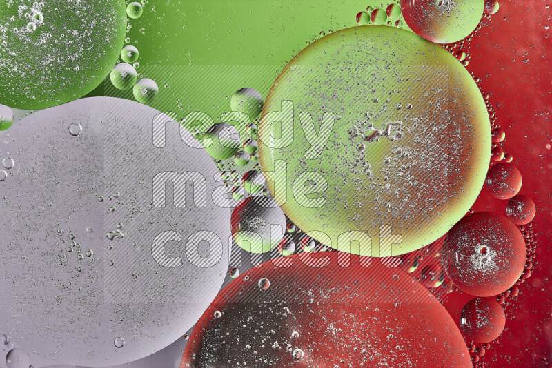 Close-ups of abstract oil bubbles on water surface in shades of red, green and white
