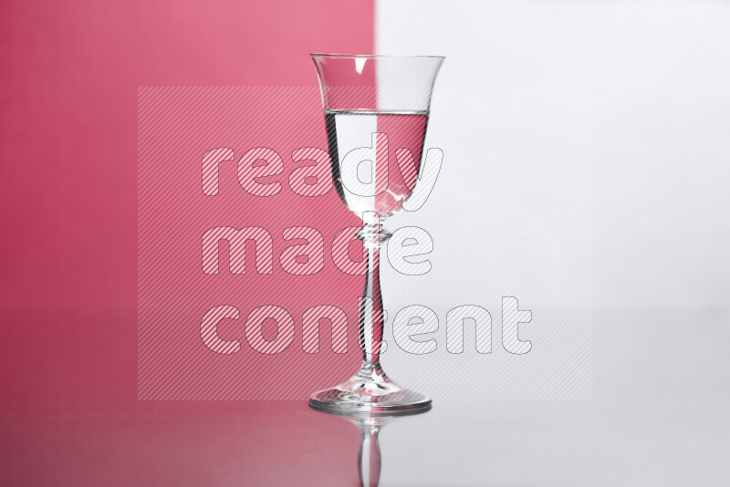 The image features a clear glassware filled with water, set against white and pink background