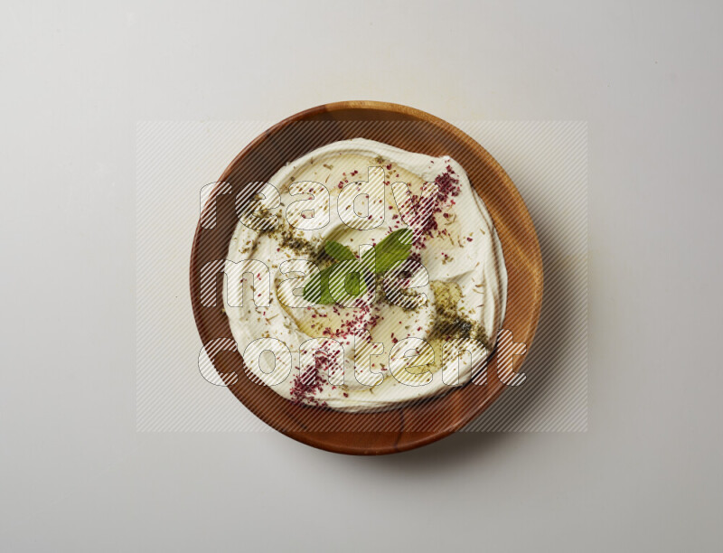 Lebnah garnished with  zattar , sumak & mint in a wooden plate on a white background