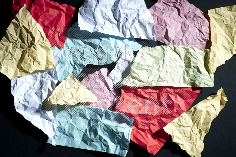 Crumpled multicolored paper on black background