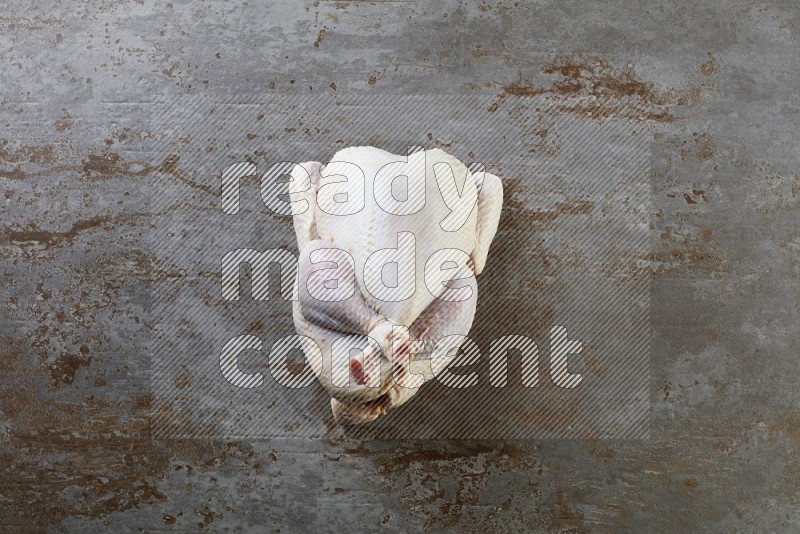 whole raw chicken  direct on a rustic grey background