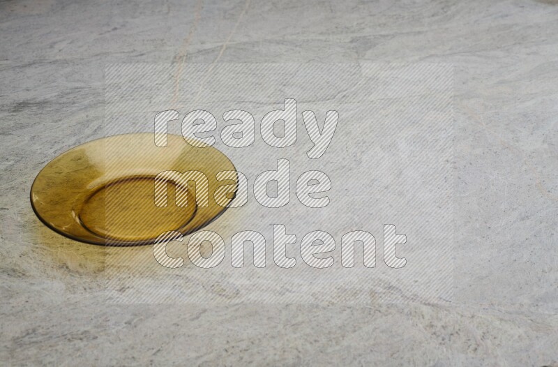 A circular glass plate on grey marble background