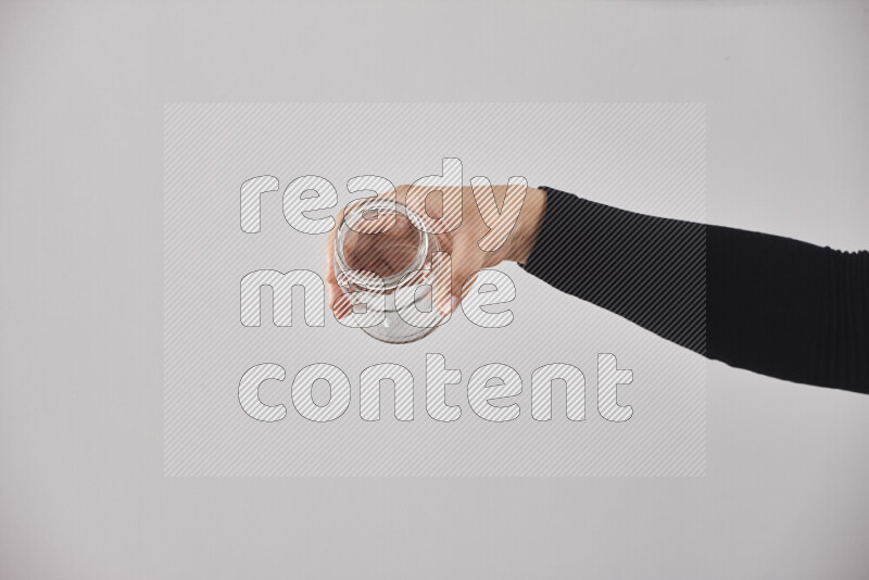 A woman in black abaya holding different glassware in different positions