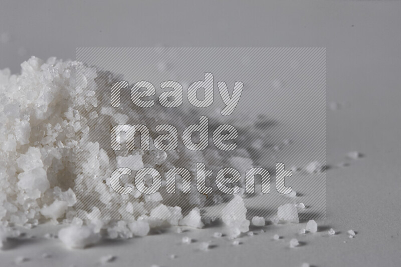 A bunch of coarse sea salt crystals on white background