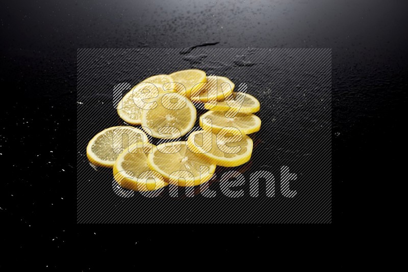 Lemon slices with water drops, and droplets on black background