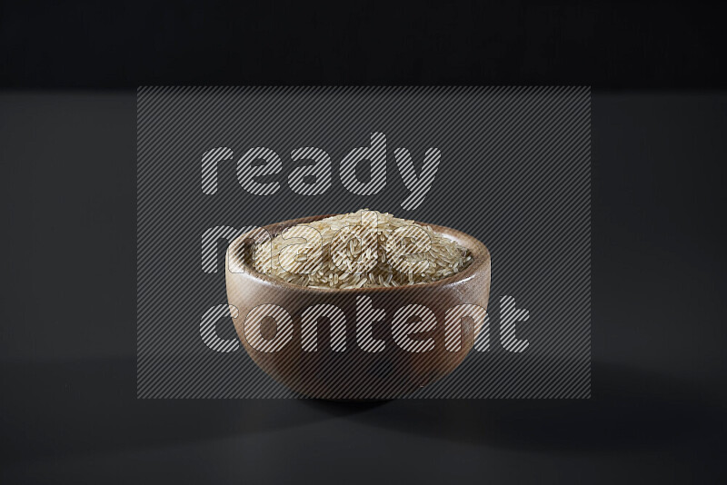 أرز بسمتي في وعاء خشبي على خلفية رمادية
