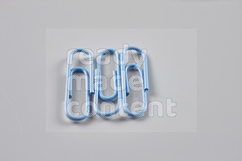 Blue paperclips isolated on a grey background