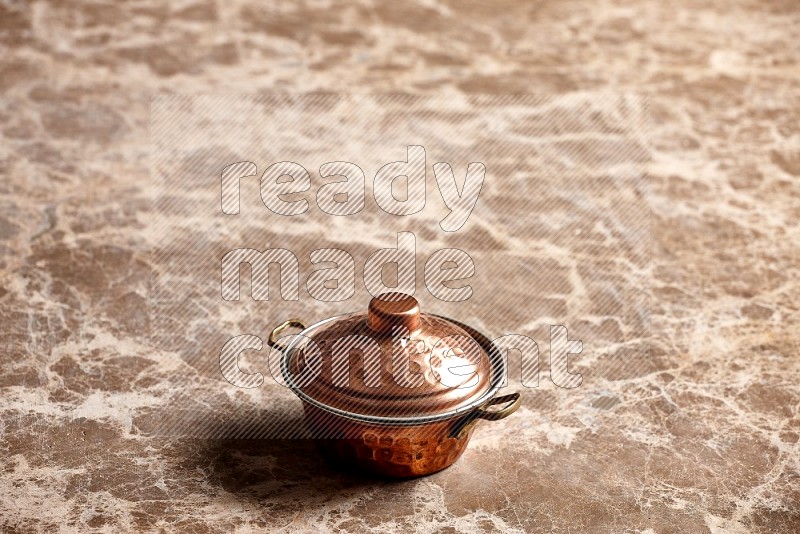 Small Copper Pot on Beige Marble Flooring, 45 degrees