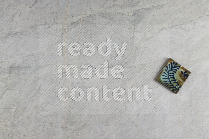 A decorative pottery coaster on grey marble background
