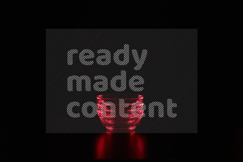 Glassware with rim light in red against black background