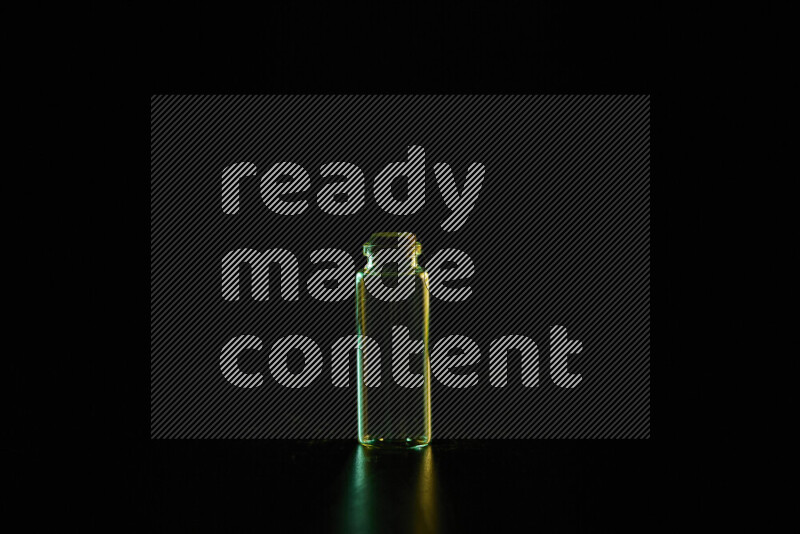 Glassware with rim light in green and yellow against black background