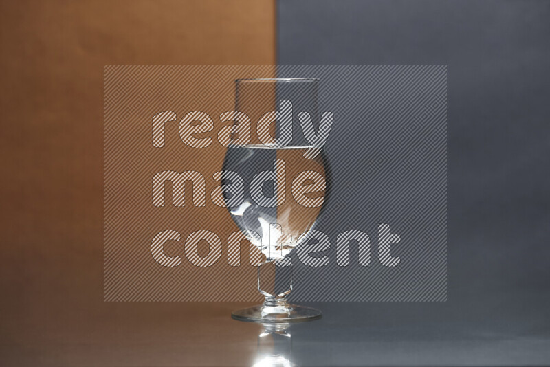 The image features a clear glassware filled with water, set against brown and dark blue background