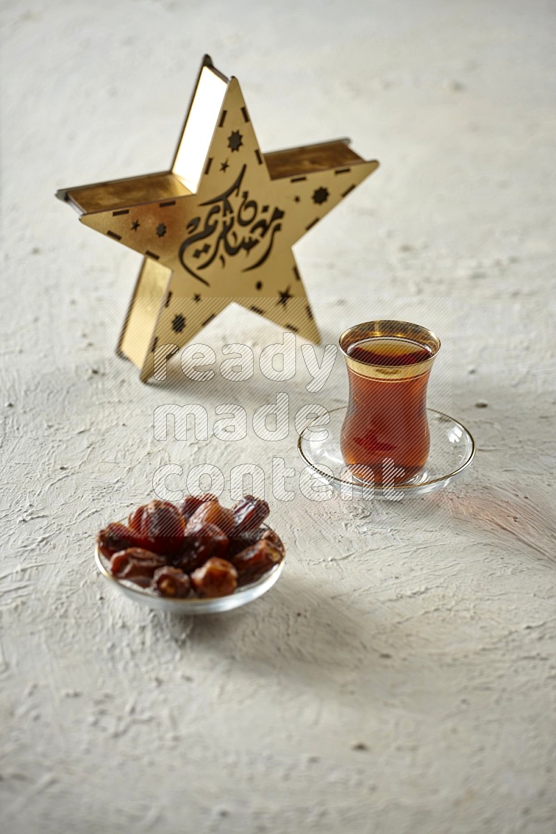 A wooden golden star lantern with different drinks, dates, nuts, prayer beads and quran on textured white background