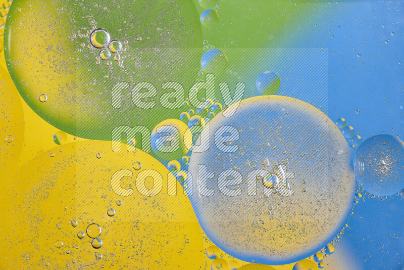 لقطات مقربة لفقاعات من الزيت على سطح الماء باللون الأصفر والأخضر والأزرق
