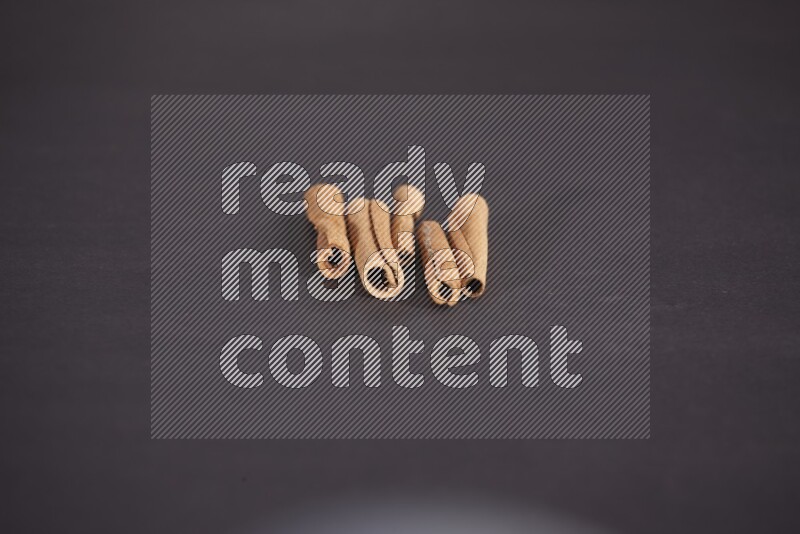 Cinnamon sticks stacked on black flooring