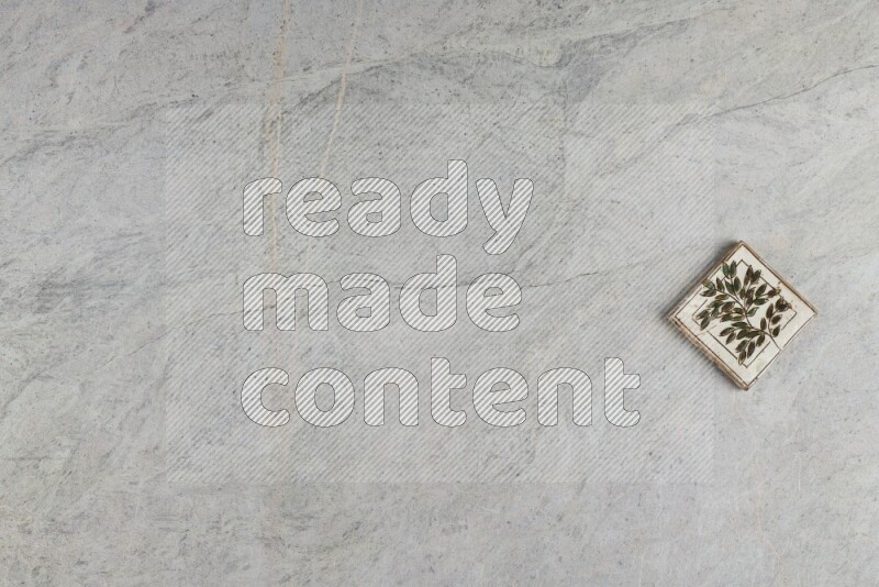 A decorative pottery coaster on grey marble background