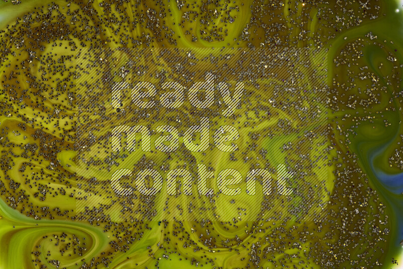 A close-up of sparkling gold glitter scattered on swirling green and red background