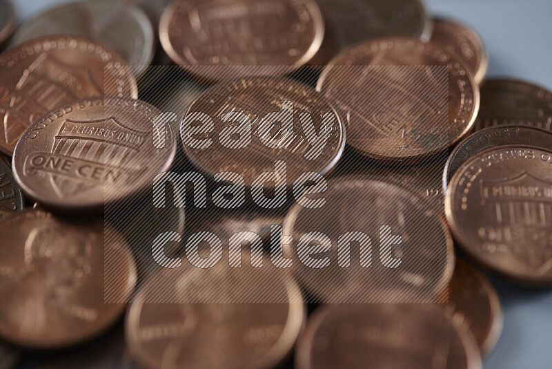 صورة مقربة لعملات معدنية متناثرة بقيمة سنت أمريكي على خلفية رمادية