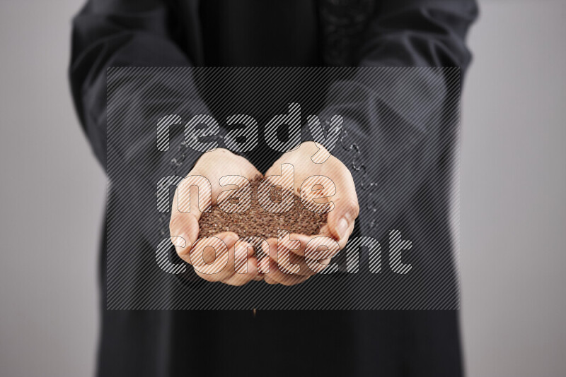 Woman in abaya holding different kinds of spices in different positions
