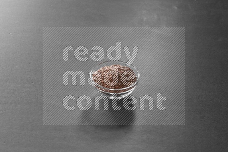 حبوب الكتان في وعاء زجاجي علي خلفية سوداء