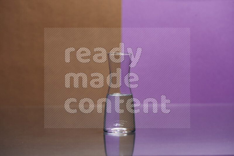 The image features a clear glassware filled with water, set against brown and purple background