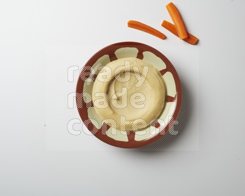 Plain hummus in a traditional plate on a white background