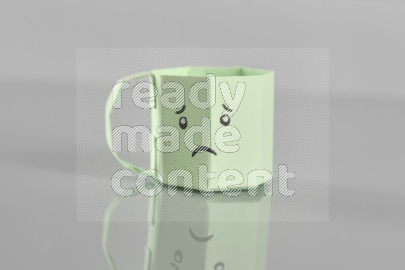 Origami cup on grey background