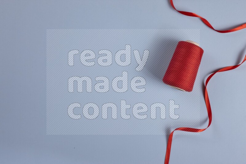 مجموعة من أدوات الخياطة والتفصيل حمراء اللون على خلفية زرقاء