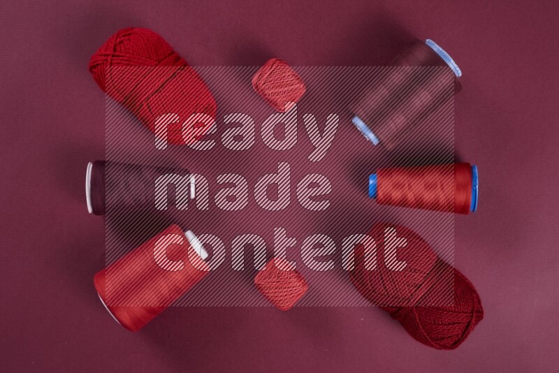 مجموعة من أدوات الخياطة والتفصيل حمراء اللون على خلفية حمراء