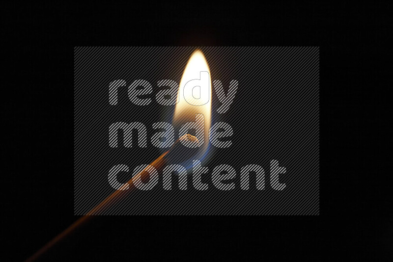 A burning matchstick isolated on dark backdrop