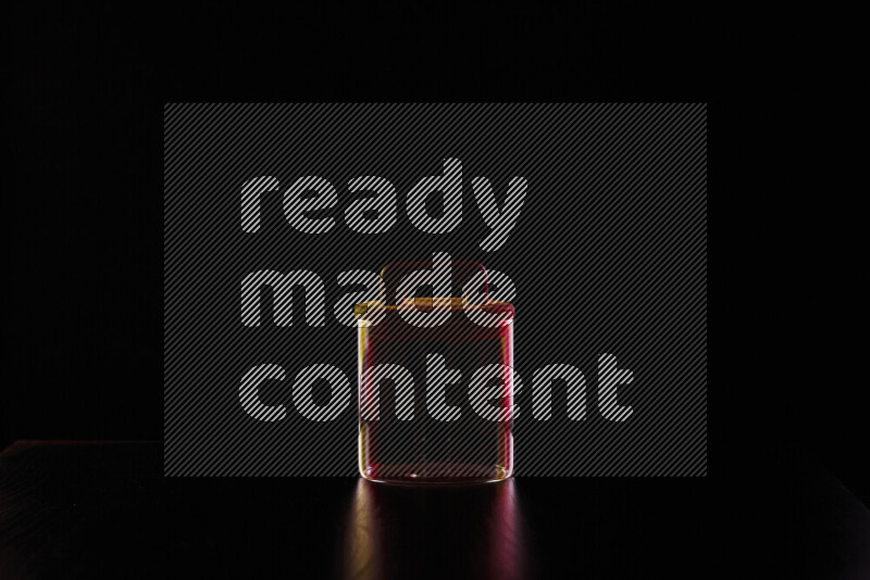 Glassware with rim light in red and yellow against black background